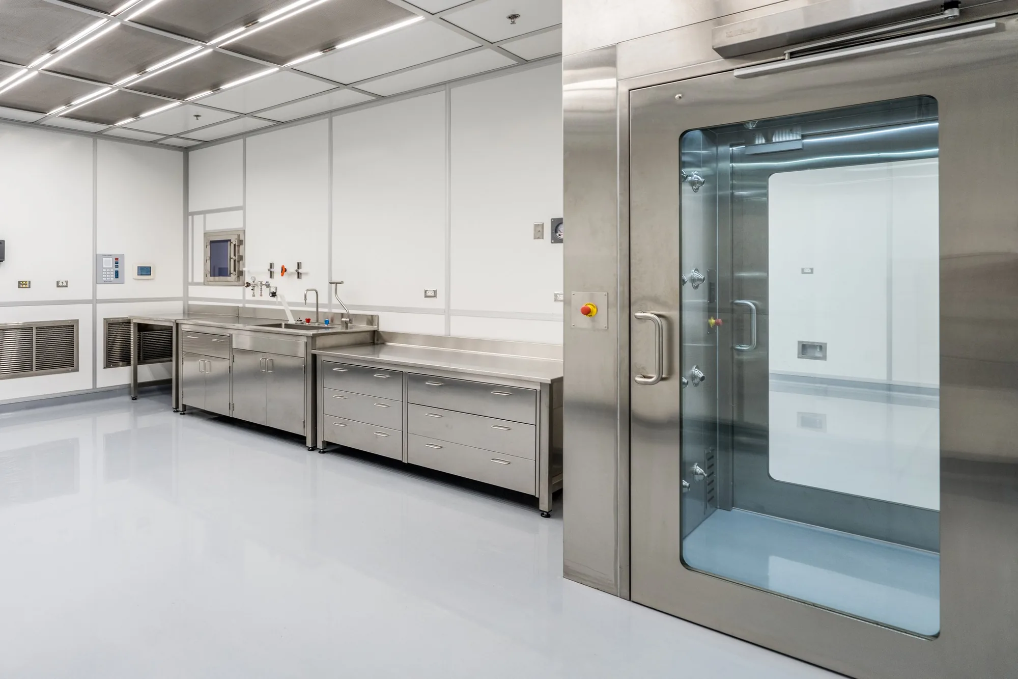 Stainless work tables and a pass-through chamber in the Building 31 clean room.